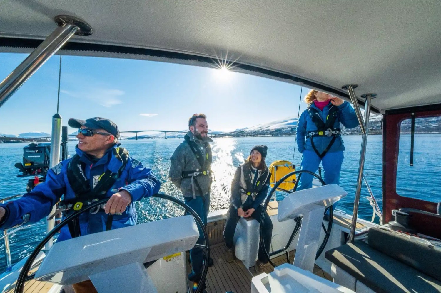 Skipper at the helm with guests in the cockpit, Northern Norway